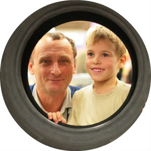 Man and Boy look through the center of a tire