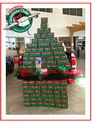 Display of Red and Green Operation Christmas Child Boxes at Toyota of Hattiesburg with Samaritan's Purse Operation Christmas Child Logo
