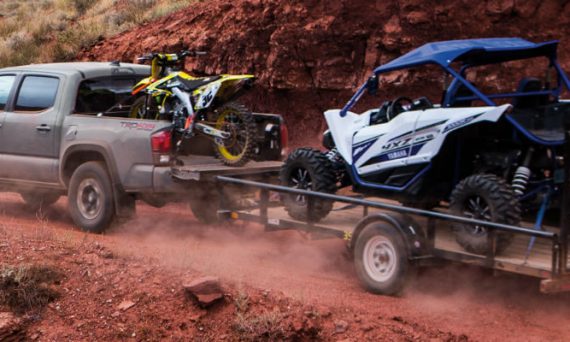 Gray 2018 Toyota Tacoma Towing an ATV Trailer with Dirt Bike in Bed in the Desert