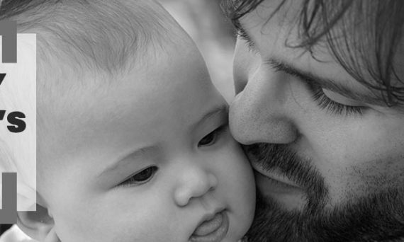 Black and White Image of Dad Holding Child with Black Happy Father's Day Text