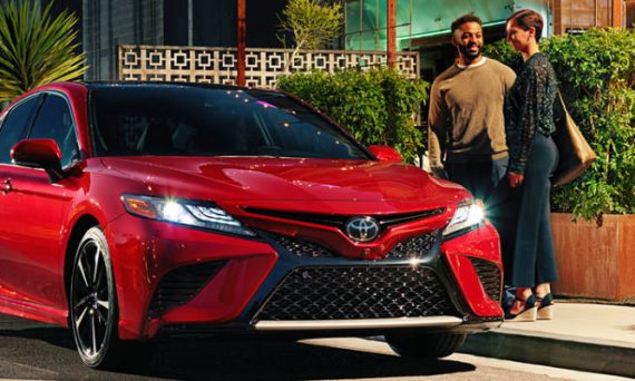 red 2019 camry with people standing next to it