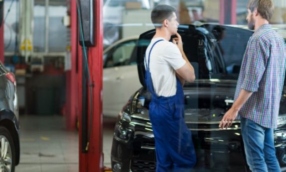 man talking to mechanic in shop